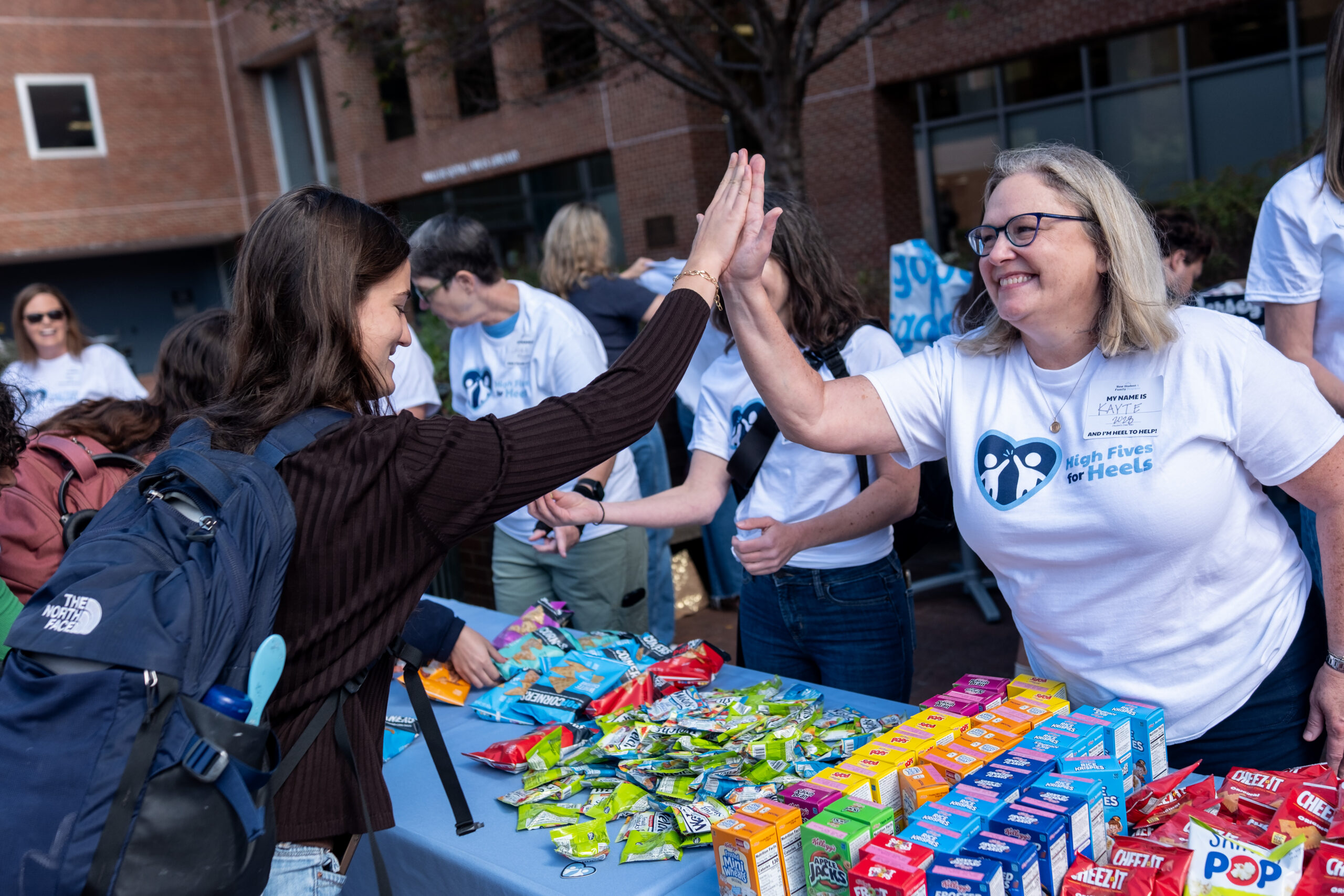 Carolina Parents Council pass out snacks and high-five students 